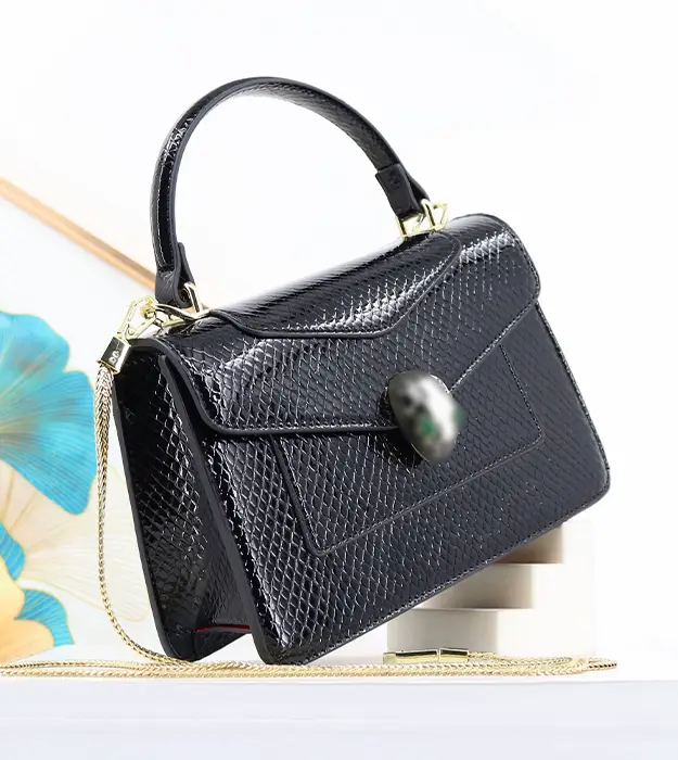 Ženska crna crossbody torba Serpentina Noir sa sjajnom teksturom i dekorativnim kopčanjem